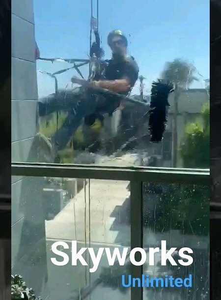 Skyworks Unlimited technician descending a glass curtain wall on ropes